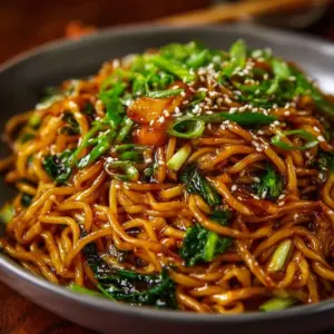 Delicious Sticky Garlic Chicken Noodles topped with green onions.