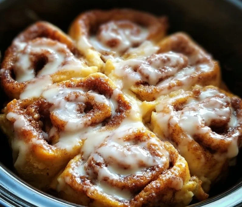 Delicious Crockpot Cinnamon Roll Casserole topped with icing and served in a bowl.