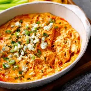 Creamy dairy-free buffalo chicken dip served in a bowl with celery sticks.