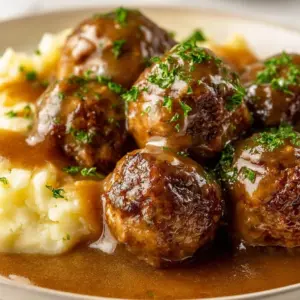 Delicious ground beef meatballs served with rich gravy on a plate.