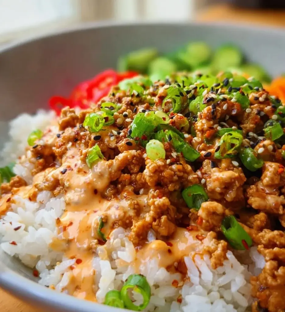 Ground turkey rice bowls with Bang Bang sauce topped with fresh vegetables