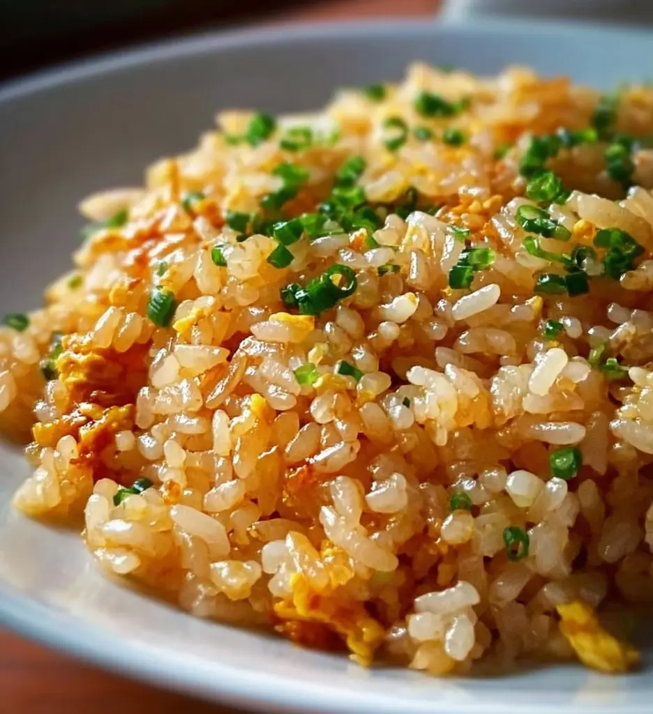 Bowl of Japanese Garlic Fried Rice garnished with green onions